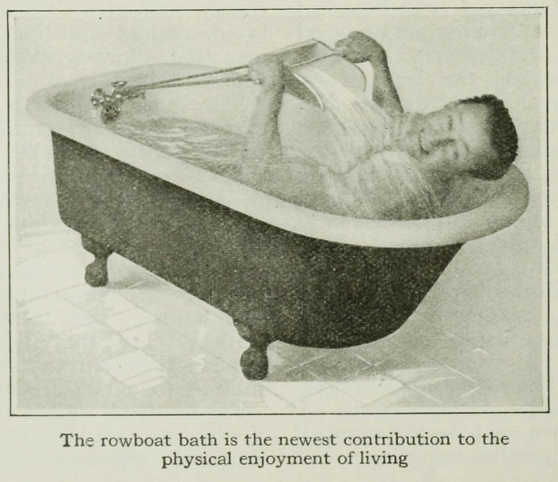 A middle-aged man in the an old-fashioned footed tub is pulling on what looks like a dustpan full of water attached by an elastic cord to the faucet area somehow. He is leaning back and grimace-smiling gratefully towards the camera. His hair is short and sloping back with the wet.