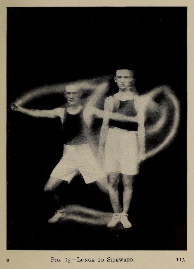 He certainly looks dashing in his flashy new tennis shoes. But is he truly activated?? An athletic 1917 business man with black tank top, white knee-length shorts, white tennis shoes, and dark hair neatly parted and just beginning to receded. A composite pose of him exercising. In this case lunging side to side. Face very serious and straight-ahead. This businessman means business!